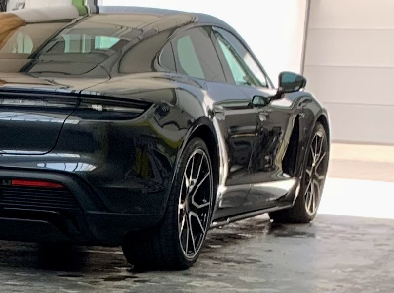 Schwarzer Porsche Taycan im Spiegelglanz nach der Aufbereitung